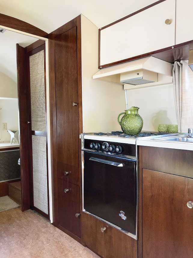Interior of restored 1961 Airstream with refurbished stove and new plumbing fixtures