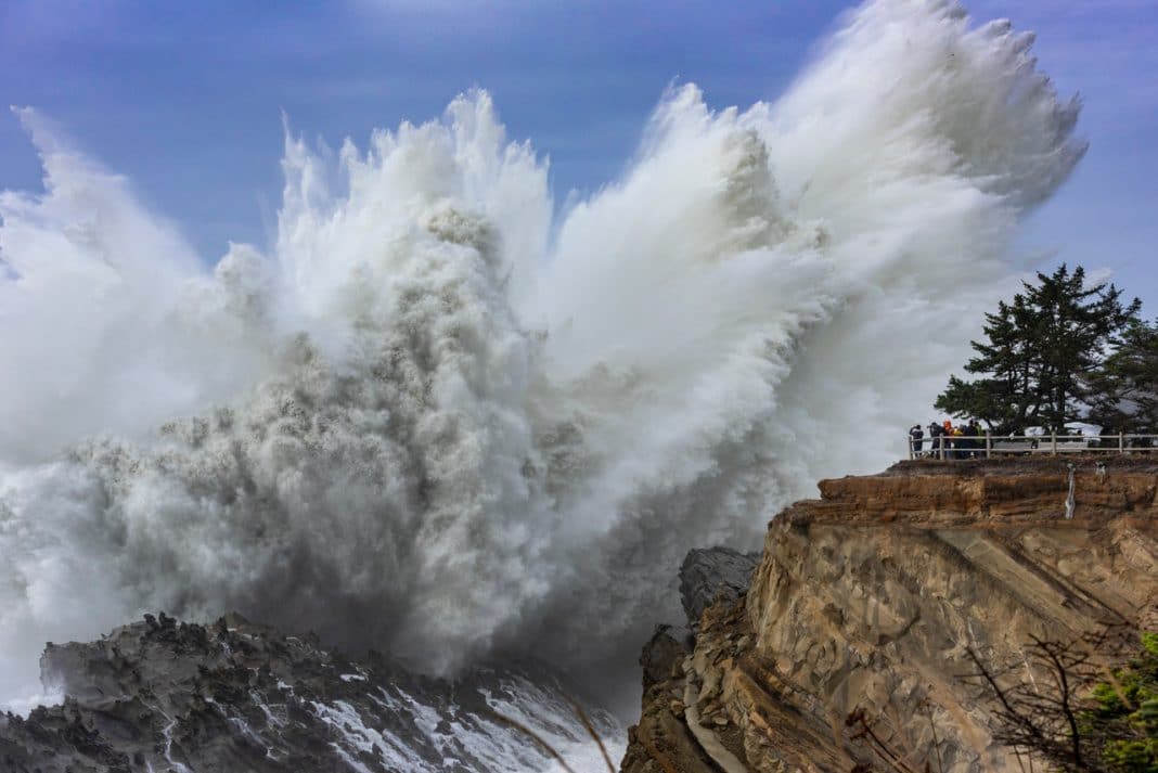 Massive ocean swell crashing on large rocky cliff during the day in Oregon