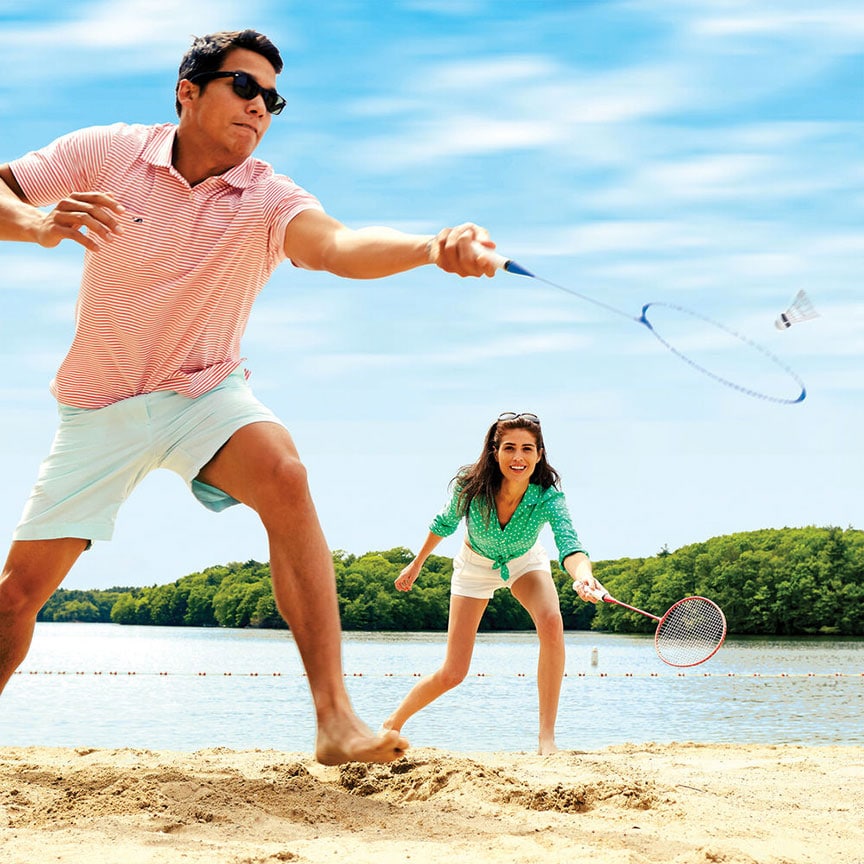Man and woman playing badminton on the beach