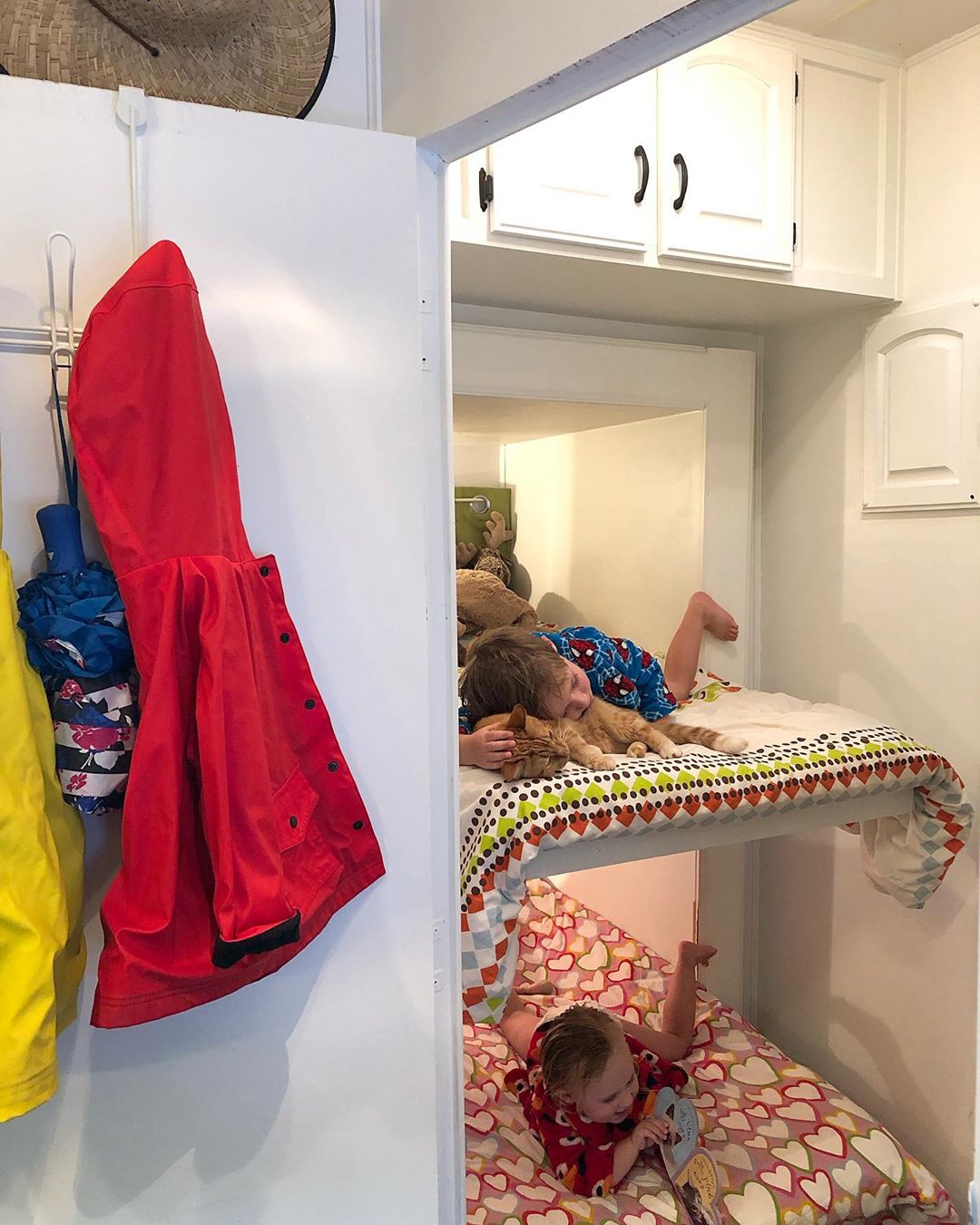 RV bunk beds with boy toddler petting cat on top bunk