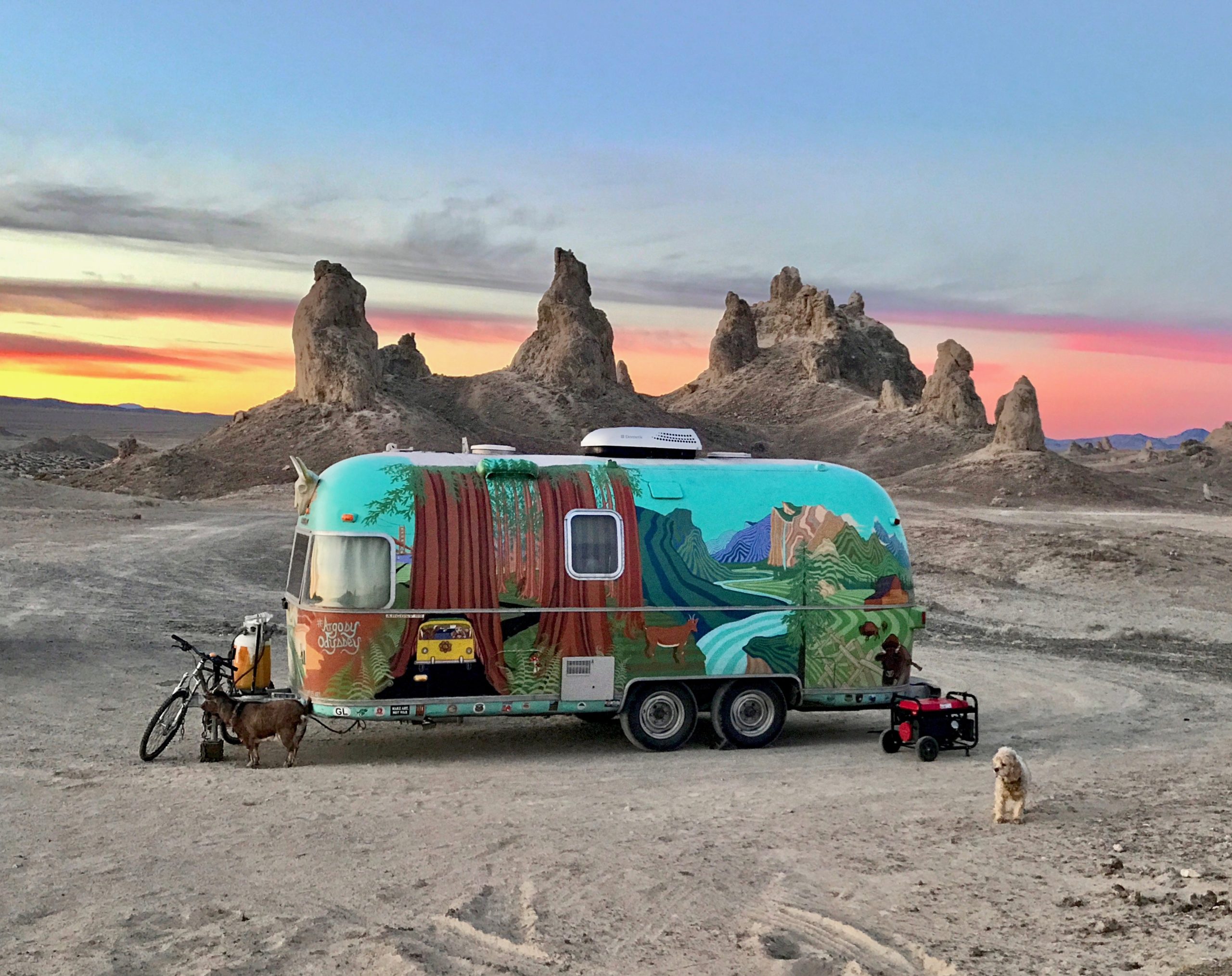 Colorful travel trailer in Trona Pinnacles desert with goat and dog