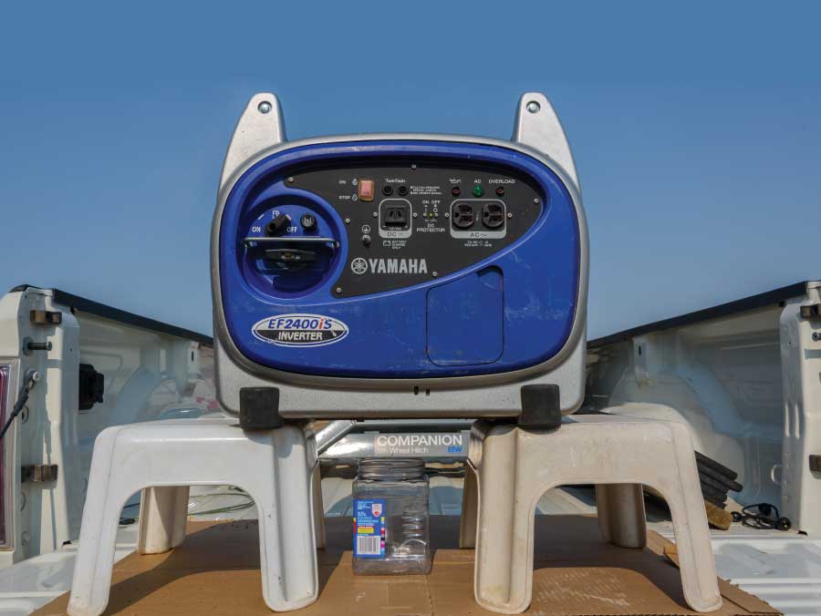 To change the oil, position the generator so a disposable container can be placed below it. Here the generator straddles two stools above an empty snack-food container.