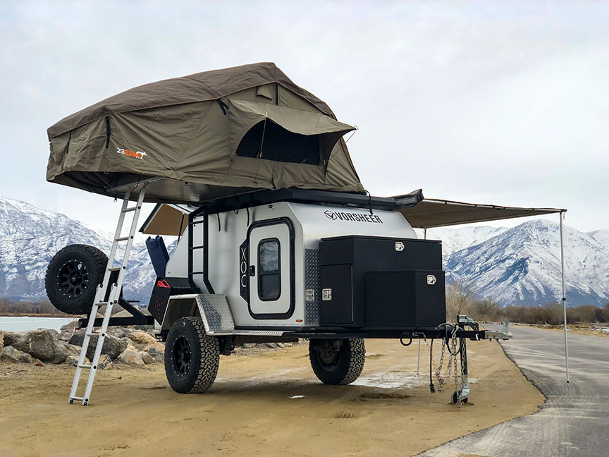 Vorsheer XOC trailer parked with rooftop tent extended and snowy mountains in background.