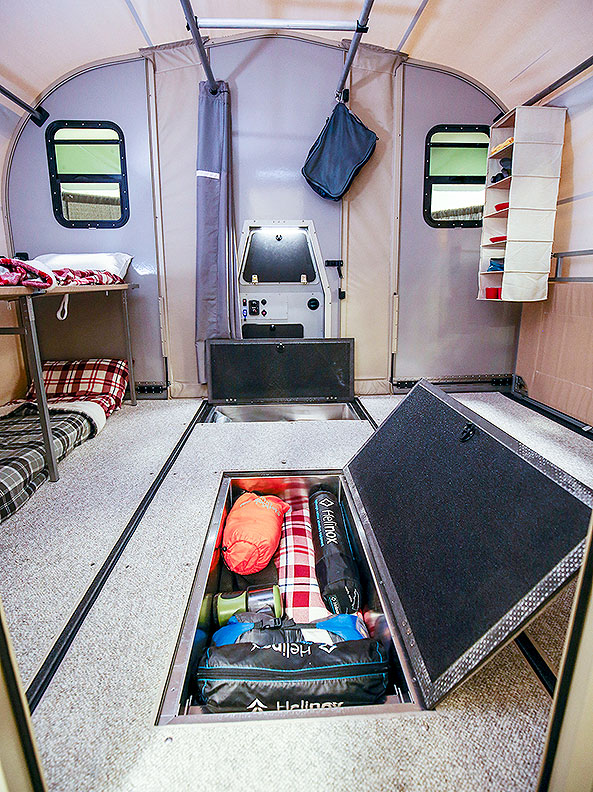 Inside view of trailer with storage panel in floor open.