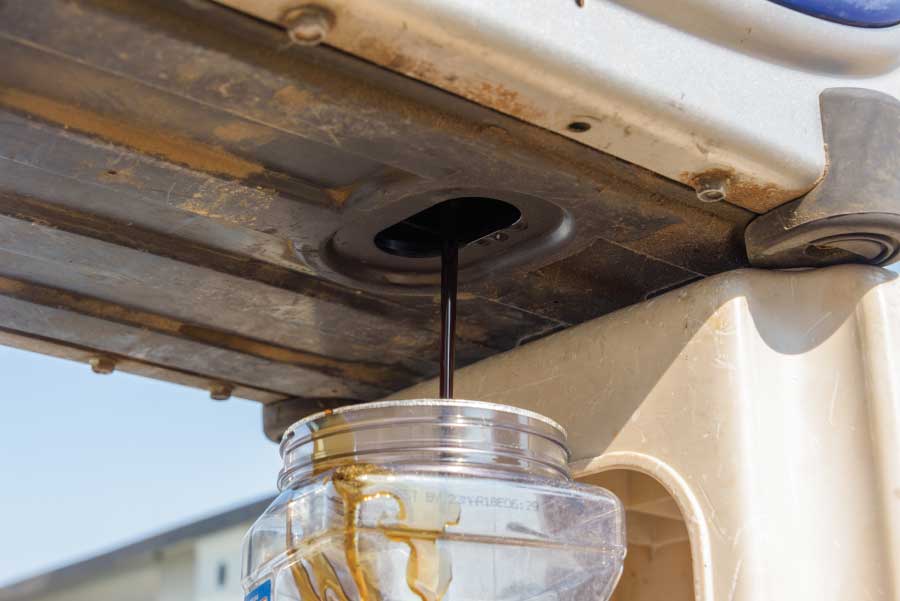 Let the oil drain out of the generator into the disposable container.