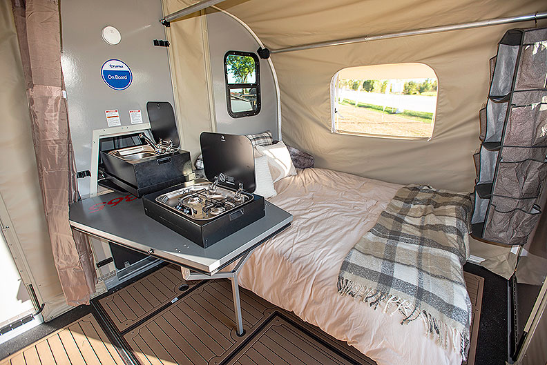 Queen bed with slide-out kitchen next to it.