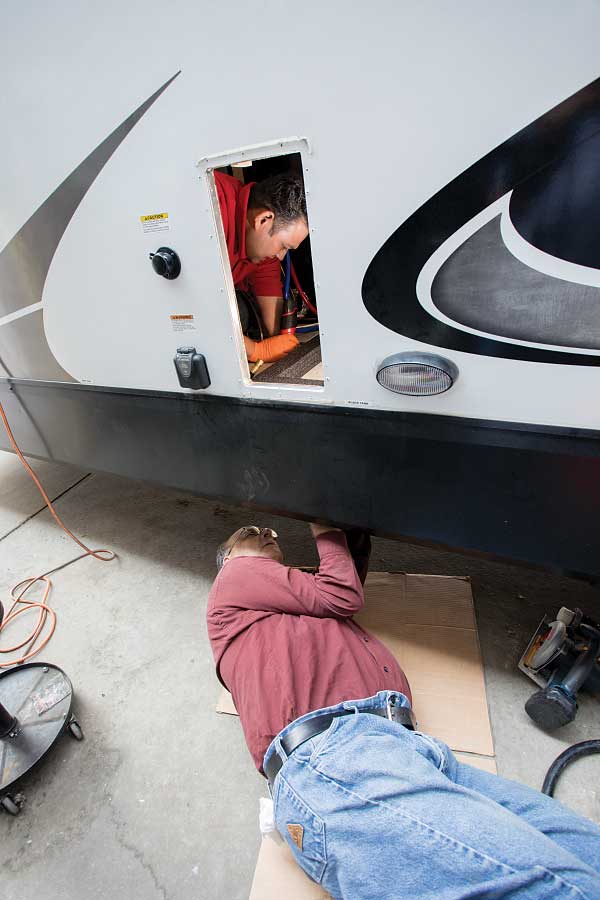 5-9) A hole is cut for the flange, and the new Aqua-Hot 250P unit is set in place, allowing for the exhaust pipe to be connected.