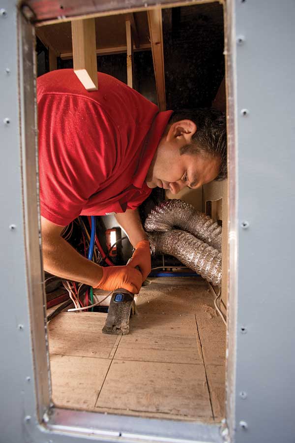 5-9) A hole is cut for the flange, and the new Aqua-Hot 250P unit is set in place, allowing for the exhaust pipe to be connected.