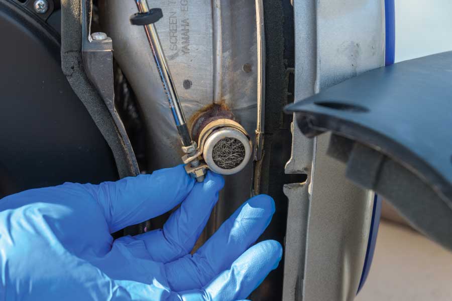 Unscrew the clamp that holds the spark arrester and inspect the wire mesh to ensure it is not full of carbon. If it is, use a wire brush to remove any carbon deposits.