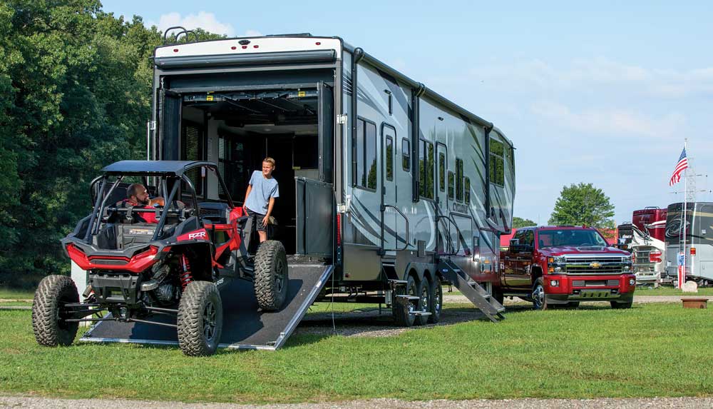 RVers unload a Polaris RZR from the garage of the Cyclone 4007 toy hauler. 