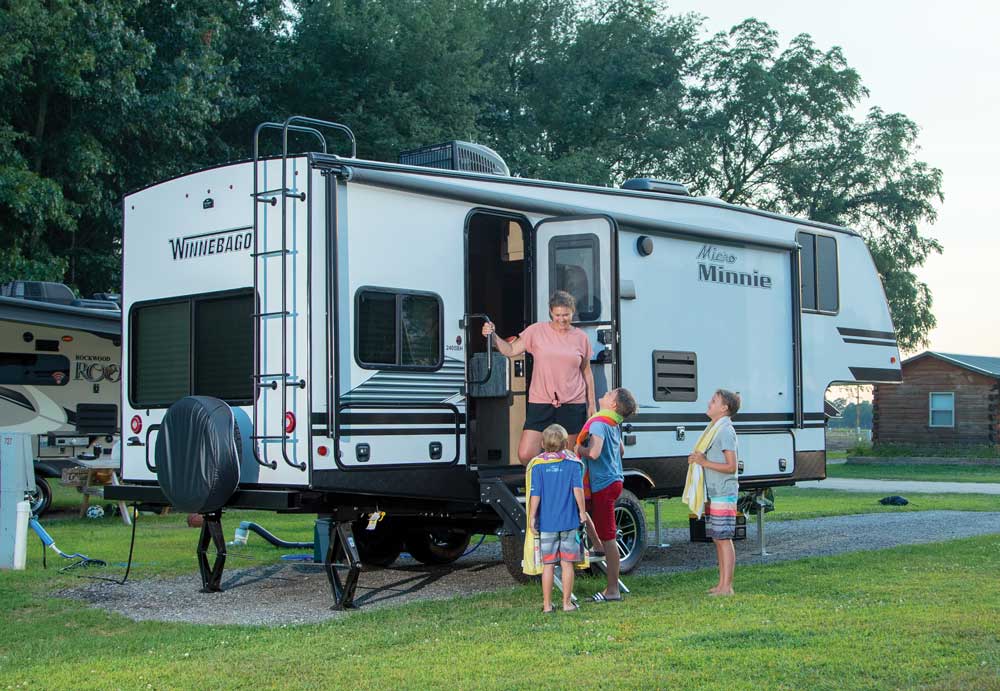 A mom and four boys gather at the steps of a winnebago Micro Minnie 2405BH