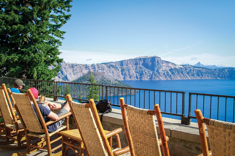 guests sitting at crater lake lodge looking over crater lake