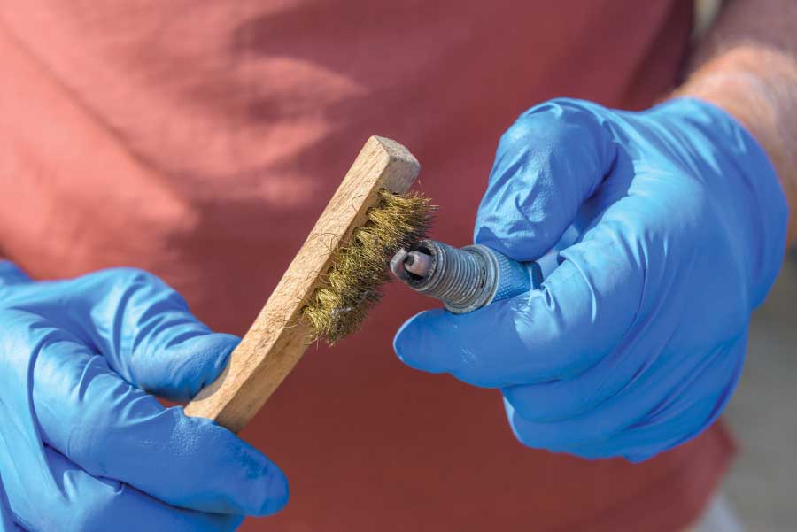 If the gap is within the specification, check its overall condition to determine if the engine is running well. The owner’s manual should spell out the kinds of wear to look for. For instance, if it is wet, the generator engine is running rich, and if it is discolored, there may be other problems. Use a wire brush to clean off any debris. When finished, take the container with the old oil to an oil-recycling center.