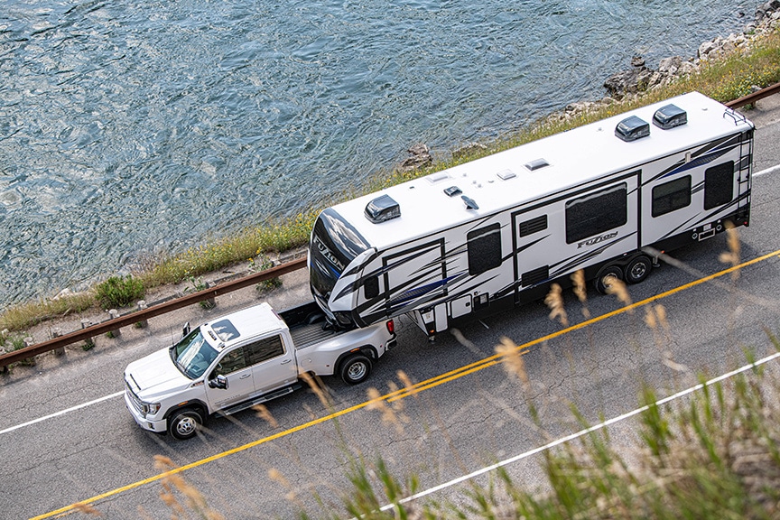 Aerial view of white Sierra truck towing a Fuzion fifth-wheel