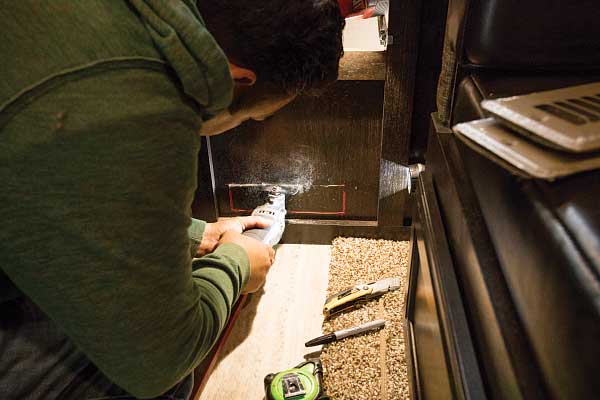 26) A hole is cut in the wood for a Whisper heat exchanger, which will be mounted in the location of the old water heater.