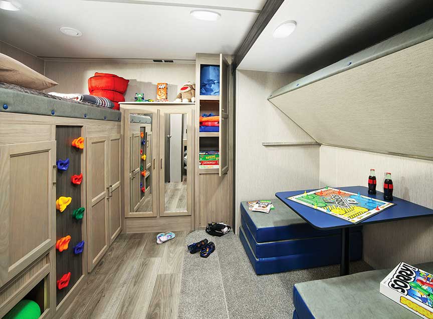 Rear bunk room in 326BHDS trailer with a climbing wall up to the top bunk.