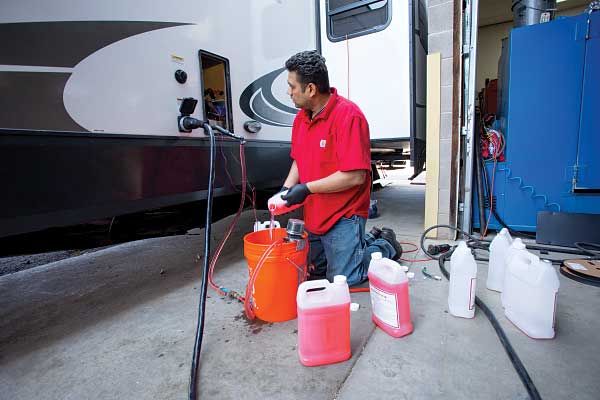 32) Antifreeze mixture is pumped into the Aqua-Hot unit. 33) The exhaust pipe is connected to the unit through the hole cut in the floor.