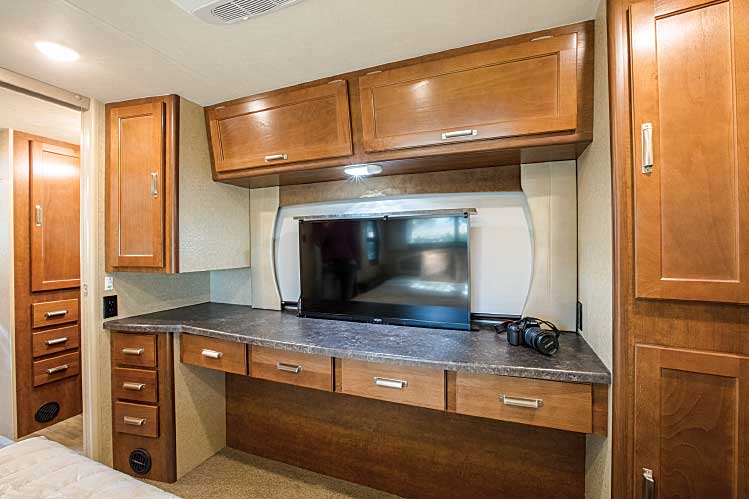 Interior, bedroom area of Lance 2465 Travel Trailer with television in the raised position