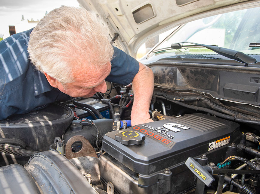 Service technician under the hood of a 6.7-liter Cummins truck.