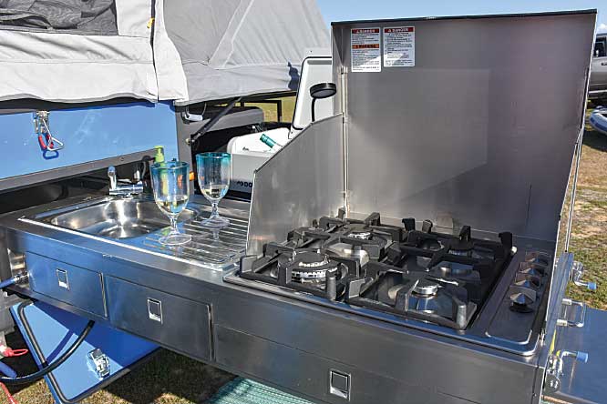 The outdoor kitchen sports a four-burner range, stainless sink, a cutlery drawer and a flexible LED light.
