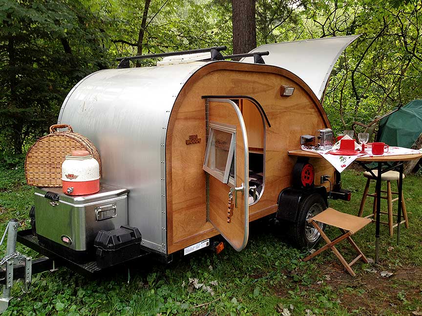 Wood-sided Big Woody teardrop trailer with rear kitchen open.