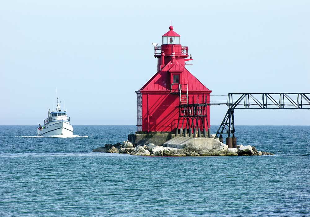 The red Sturgeon Bay Canal North Pierhead Light welcomes mariners at the Lake Michigan entrance to the Sturgeon Bay Ship Canal just outside the city of Sturgeon Bay.