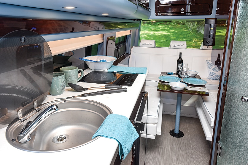 The galley is compact but well- equipped, with a single-basin sink, induction cooktop, microwave and refrigerator/freezer.