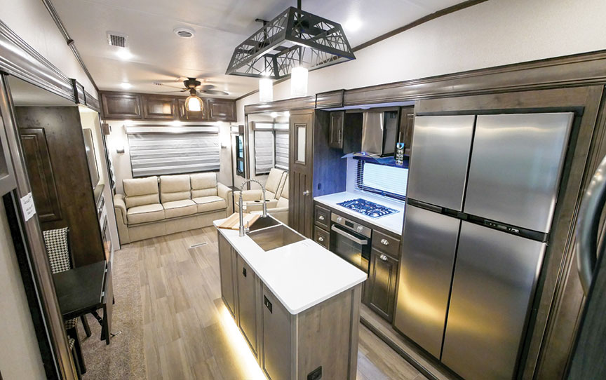 Living area and kitchen island of Cardinal Luxury 345RLX fifth-wheel