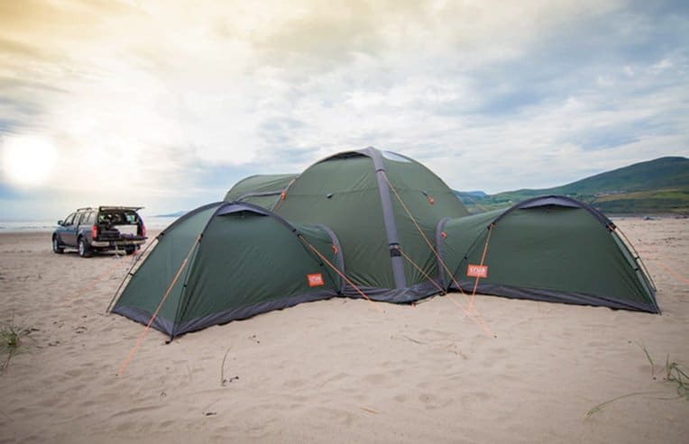 Core tent with three Duo tents connected on the beach with SUV in background