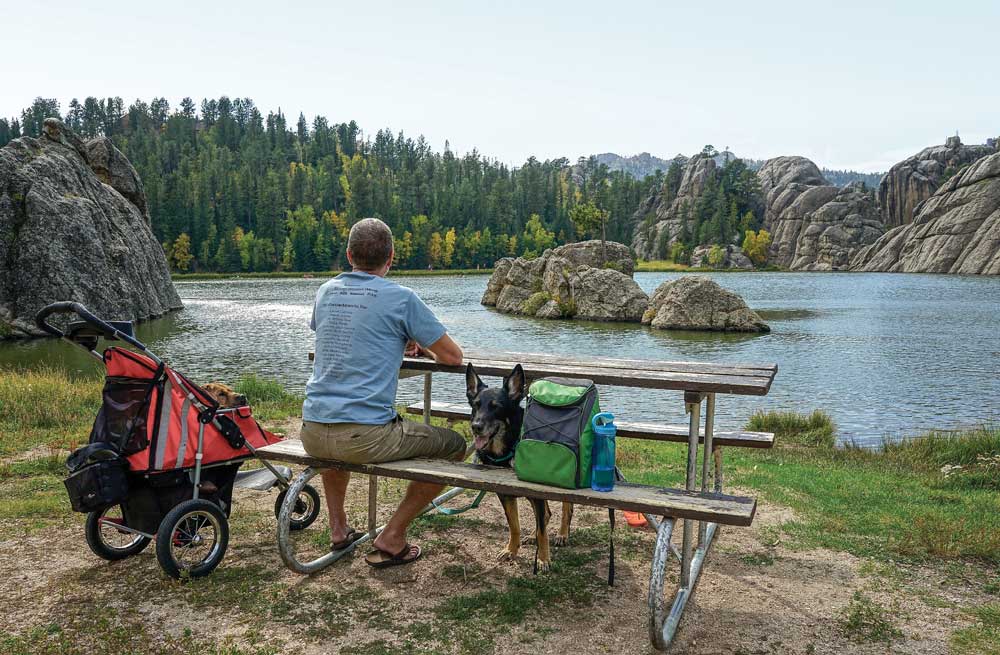 A man with dog enjoys the sites at Custer State Park, South Dakota