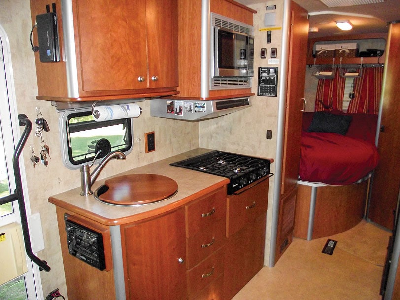 Warm cherry woodwork, graceful curved cabinetry and stainless-steel appliances give the galley a modern feel.