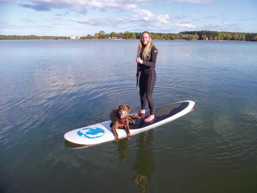 An all-around fiberglass board has enough volume to float a paddler and her pet.