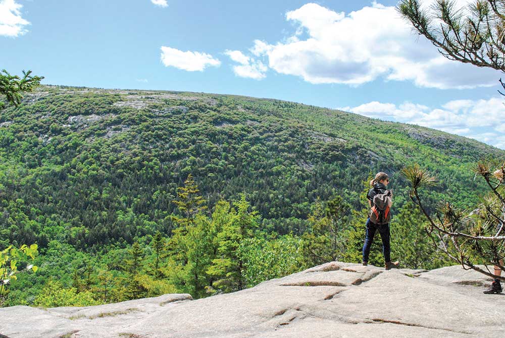 A hiker peers out from the top of South Bubble Mountain.