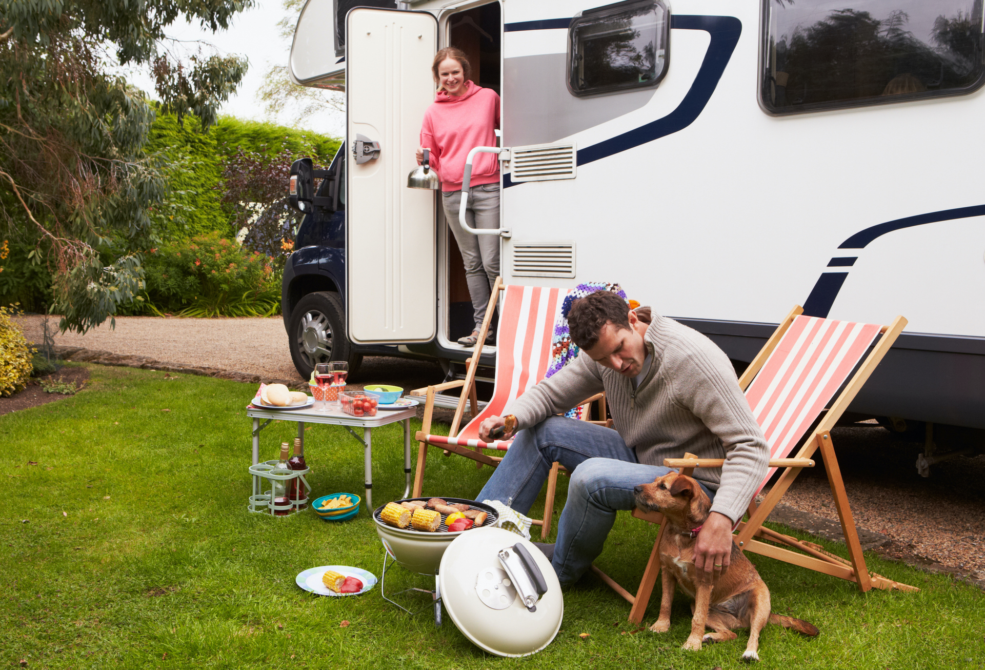 Couple In Van Enjoying Barbeque On Camping Holiday