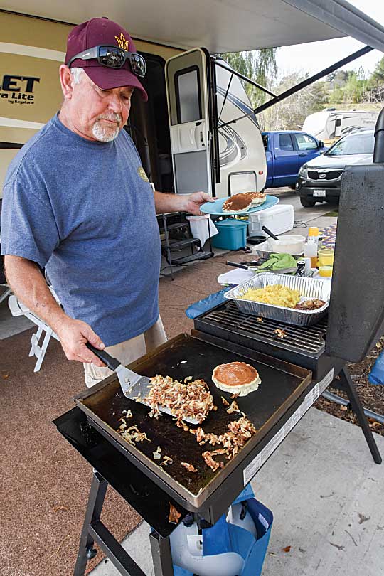 Cooking a traditional campsite breakfast on an outdoor grill on an RV patio