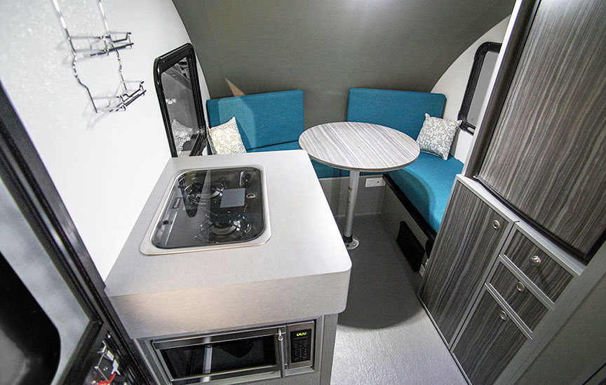 Inside trailer showing the cooktop, table and bench seats.