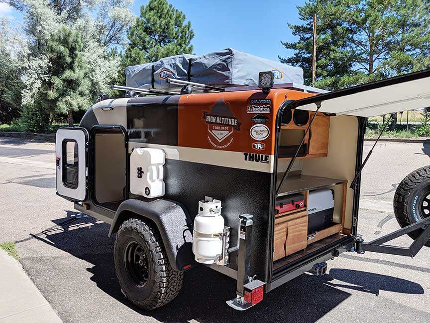 Parked XT50 trailer with rear door open and slide-out extended.