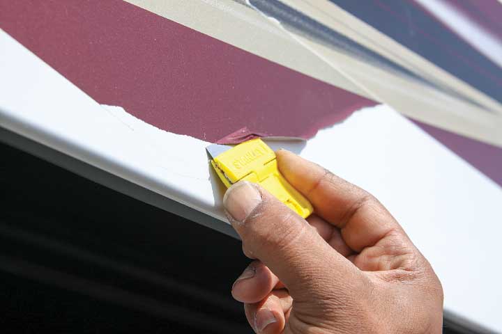 A razor blade is used to remove the old graphics.