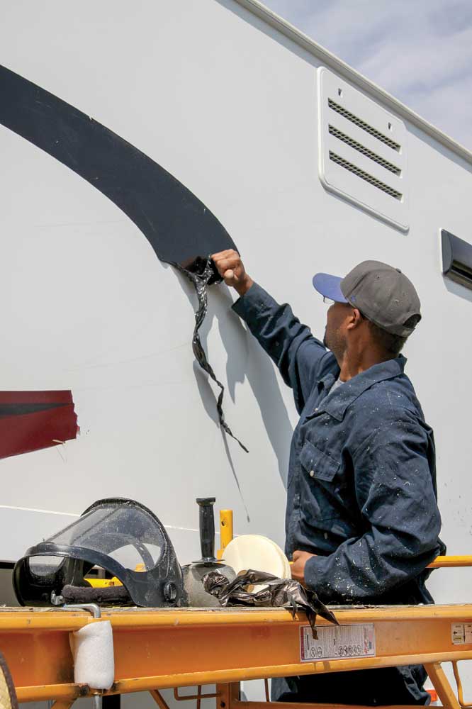 Darker-color vinyl is easier to remove than lighter counterparts. Here, the installer can remove big sections of vinyl by hand, even though it’s the same age as the rest of the original material.