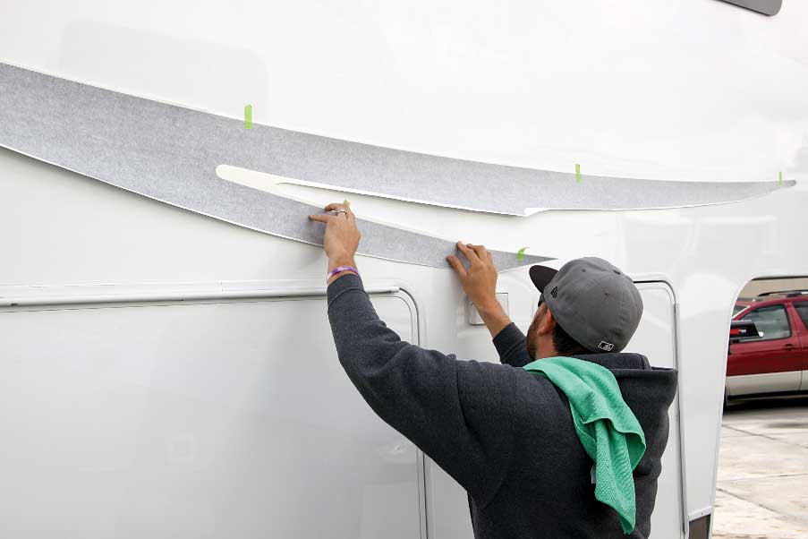 To start the process, the new graphics are placed over the ghost outlines and held in place temporarily with masking tape.