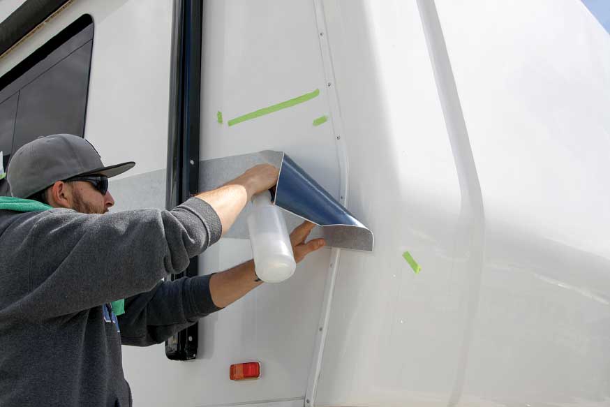The installer uses a mixture of water and baby shampoo to move the new vinyl into position without sticking.