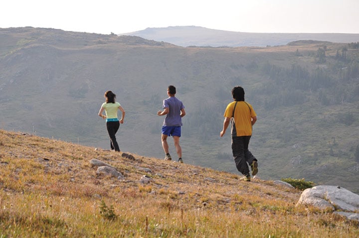 Three people running on trail to stay fit