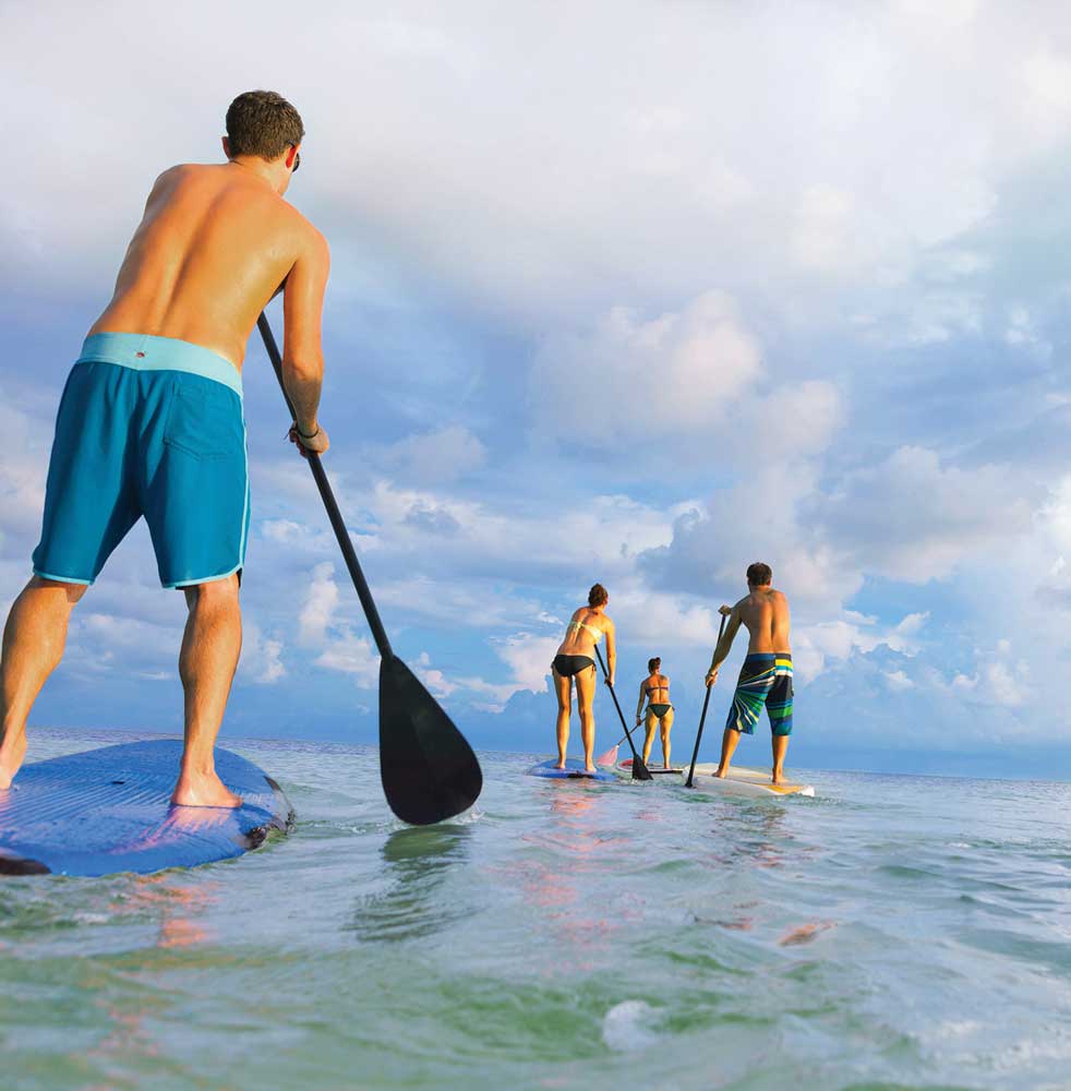 Two men and two women paddle boarding in Florida