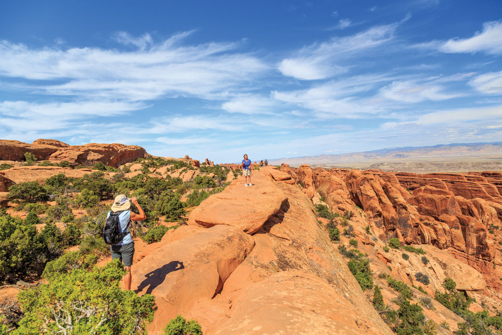 In Arches, the trail to Double O Arch turns primitive after Landscape Arch, with narrow rock fins and exposure to heights.