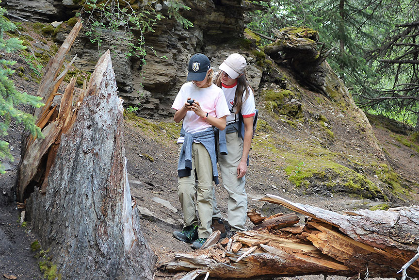 Mother and son consulting a GPS device outdoors.