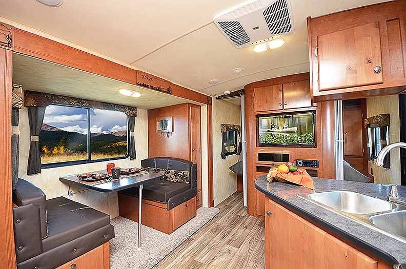 Warm brown cabinetry surrounds the booth dinette in a slideout.