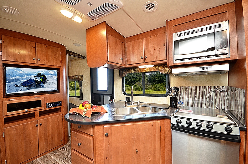 Dark colored L-shaped countertop with warm brown cabinets