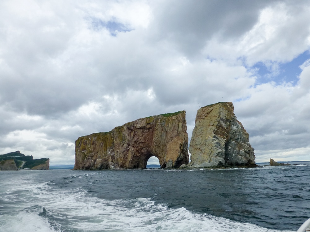 In the PercÃ© harbor, a pierced limestone island rises 289 feet. 