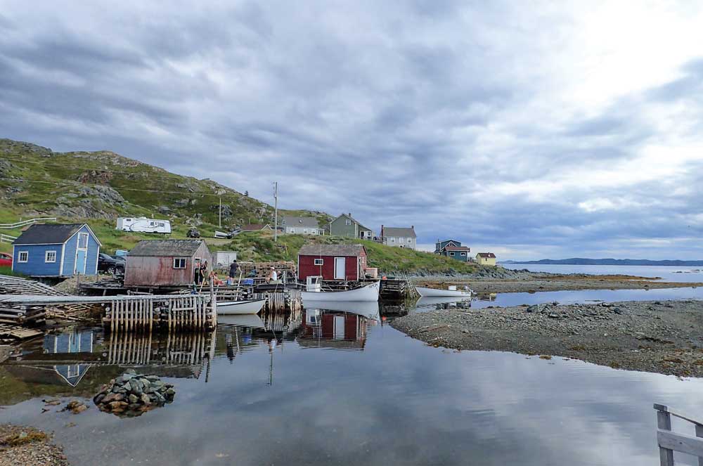 Twillingate buildings on the water with hills and a stormy sky