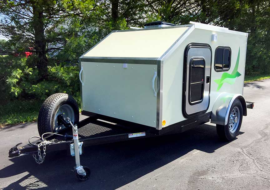 White PeeWee trailer with bright green graphic on side.